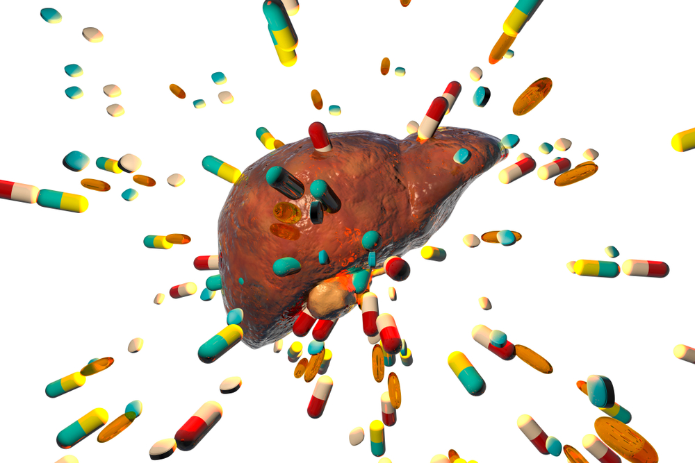Imagem de um fígado com cápsulas de remédio em volta